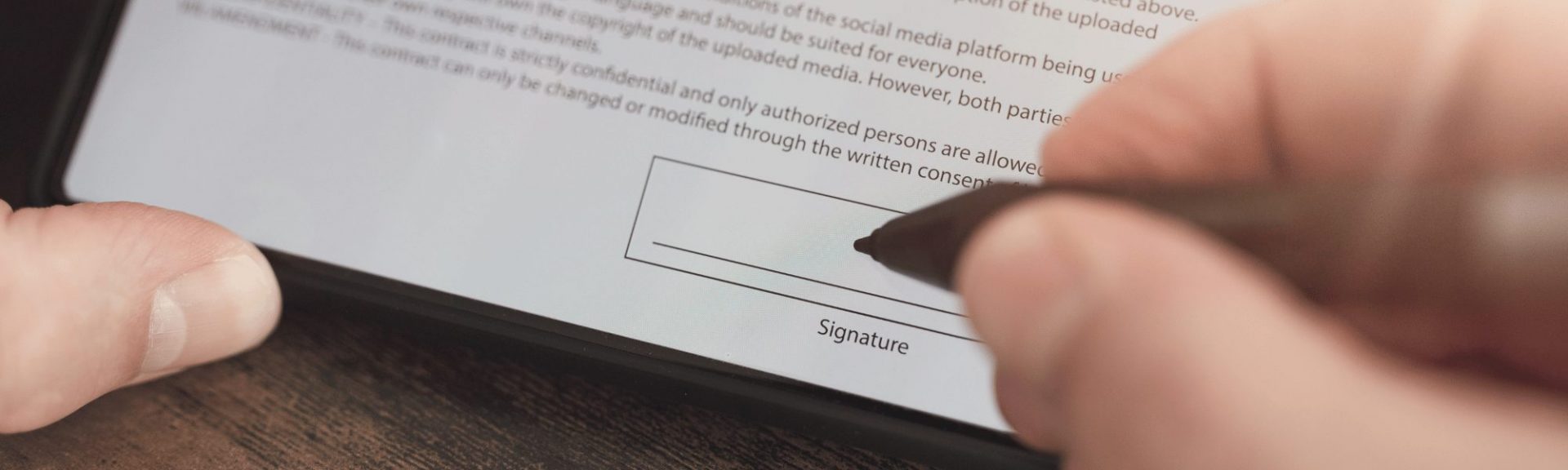 person signing document on a tablet device